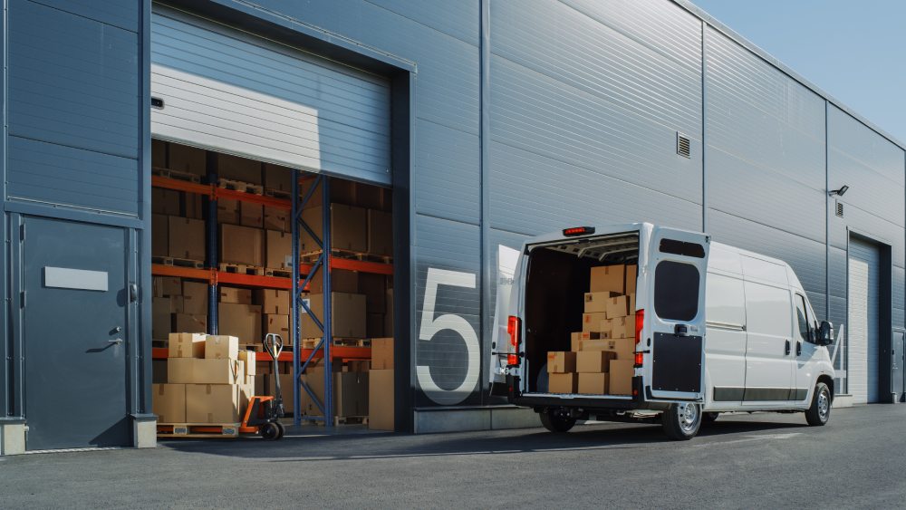 A delivery van being loaded up with boxes.